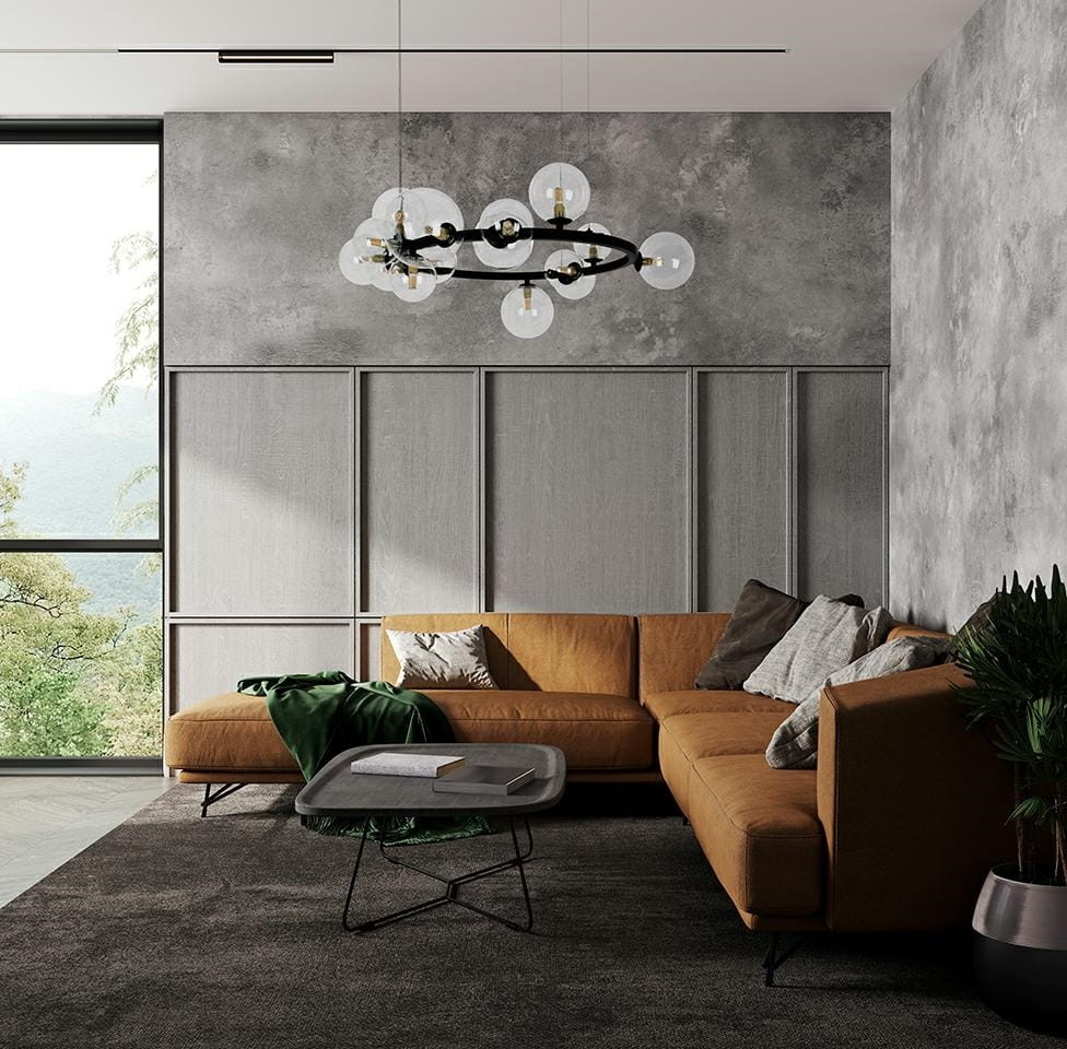 Lampa wisząca Alure Line 85, czarna, 15-punktowa, umieszczona nad sofą w nowoczesnym salonie. Szklane klosze w kształcie kul, elegancko kontrastujące z betonową ścianą i jasnym drewnem. Otoczenie z roślinnością oraz minimalistycznymi meblami.