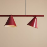 Czteropunktowa lampa wisząca Form Red Wine z czerwonymi kloszami w kształcie stożków, zawieszona na cienkim czarnym przewodzie. Klosze mają jasne wnętrze, a całość umieszczona na gładkim, jasnobrązowym tle.