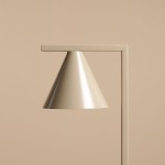 Lampa stołowa Form Beige 1-punktowa, z metalowym kloszem w kształcie stożka w odcieniu beżowym. Uchwyt w kształcie prostokąta, kolor dopasowany do klosza. Produkt prezentowany na jednolitym, jasnym tle.