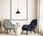 Czarna lampa wisząca Drello PND-541101-BK o stożkowym kształcie, zawieszona nad okrągłym stołem. Lampa ma długi kabel i minimalistyczny design, idealnie komponując się z nowoczesnym wnętrzem z dwiema fotelami. Tło w jasnych odcieniach.