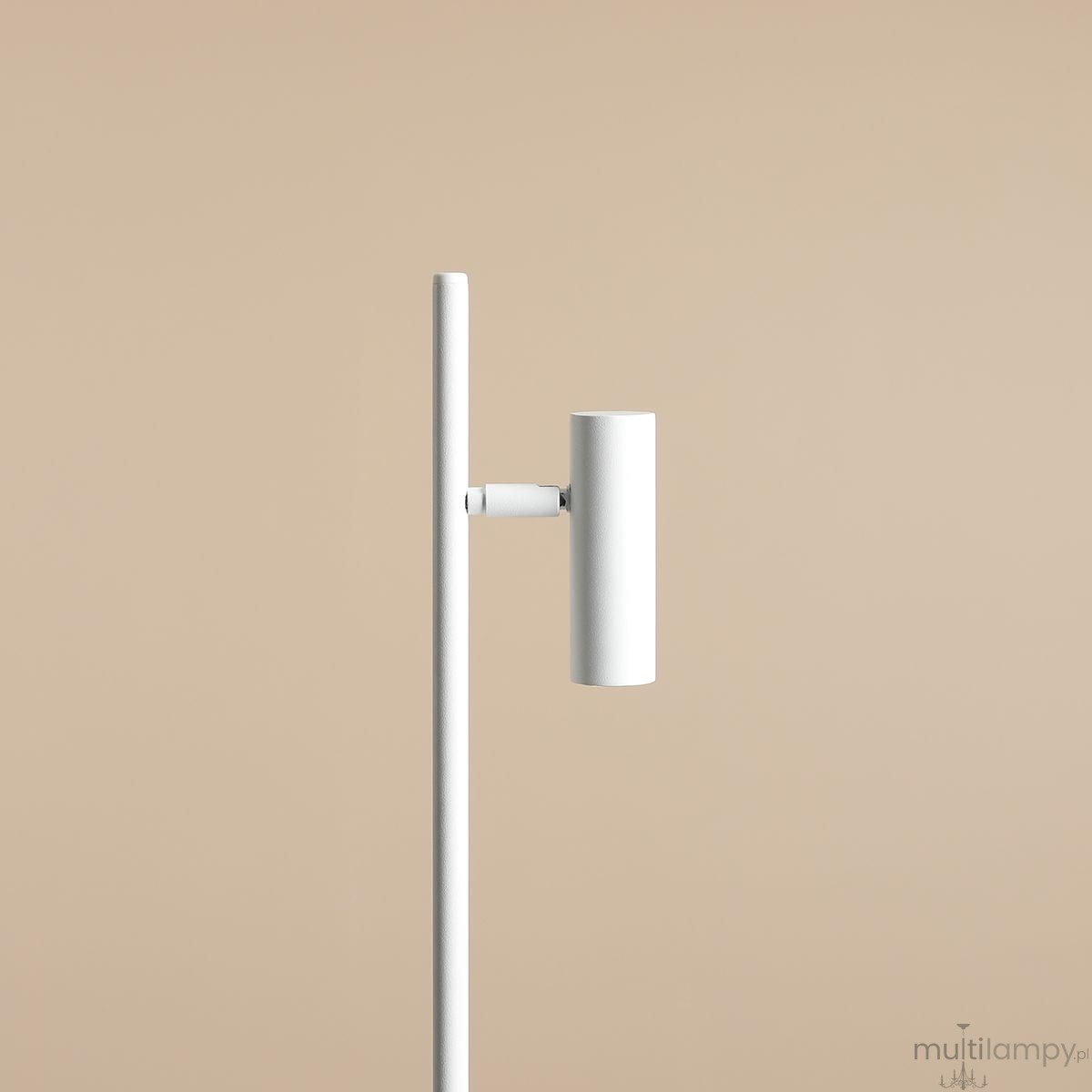 Biała lampka biurkowa Trevo 1104B, z cylindryczną głowicą zamontowaną na prostym, pionowym stelażu. Lampka ukazana z boku na jednolitym tle, podkreślająca minimalistyczny design i gładką fakturę powierzchni.