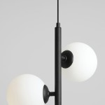 Lampa wisząca Fin S w kolorze czarnym z trzema punkami świetlnymi. Konstrukcja z metalowym słupem i białymi, okrągłymi kloszami z matowego szkła. Ujęcie z góry, pokazujące detale mocowania i kształt kloszy. Tło szare.