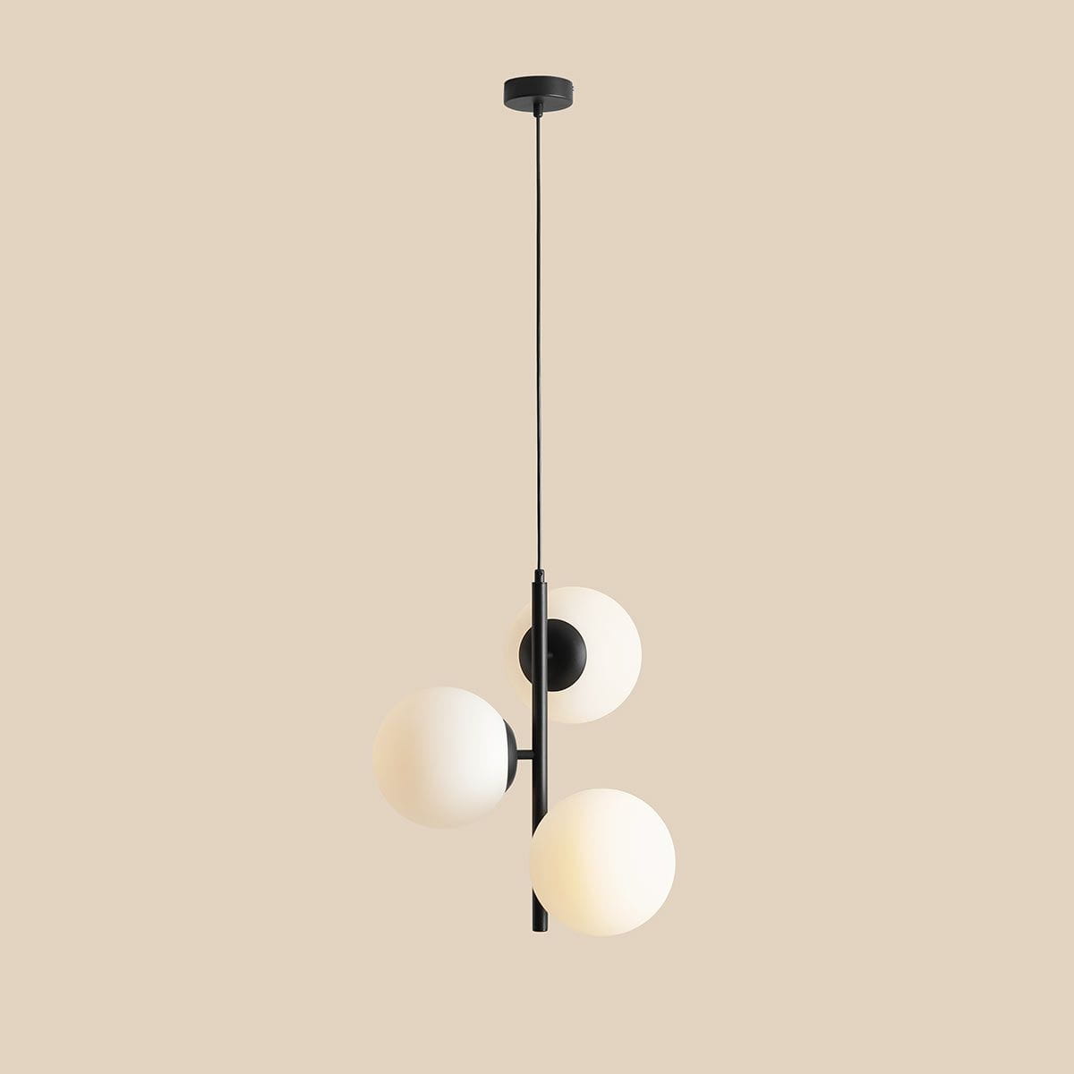 Lampa wisząca Fin M 3-punktowa w kolorze czarnym, z trzema okrągłymi kloszami w odcieniu białym. Produkt zawieszony na cienkim kablu, z górnym mocowaniem sufitowym. Idealna do nowoczesnych wnętrz.