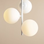 Lampa wisząca Fin M w kolorze białym z trzema okrągłymi kloszami, wykonanymi z matowego szkła. Klosze w odcieniu ciepłej bieli zawieszone na prostym, białym stelażu. Zdjęcie zbliżeniowe na lampę na jednolitym, jasnym tle.