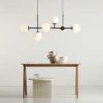 Lampa wisząca Fin 6-punktowa w kolorze czarnym z sześcioma okrągłymi kloszami w odcieniu białym, zawieszona nad drewnianym stołem. W tle widoczne dekoracje: wazon i ceramiczny element dekoracyjny. Proste, jasne tło.