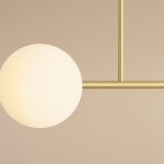 Lampa sufitowa Dione w kolorze mosiądzu z czterema punktami świetlnymi, z zaokrąglonym, białym kloszem ze szkła. Produkt zamontowany na prostym, metalowym stelażu, widoczny z bliska, na jednolitym tle.