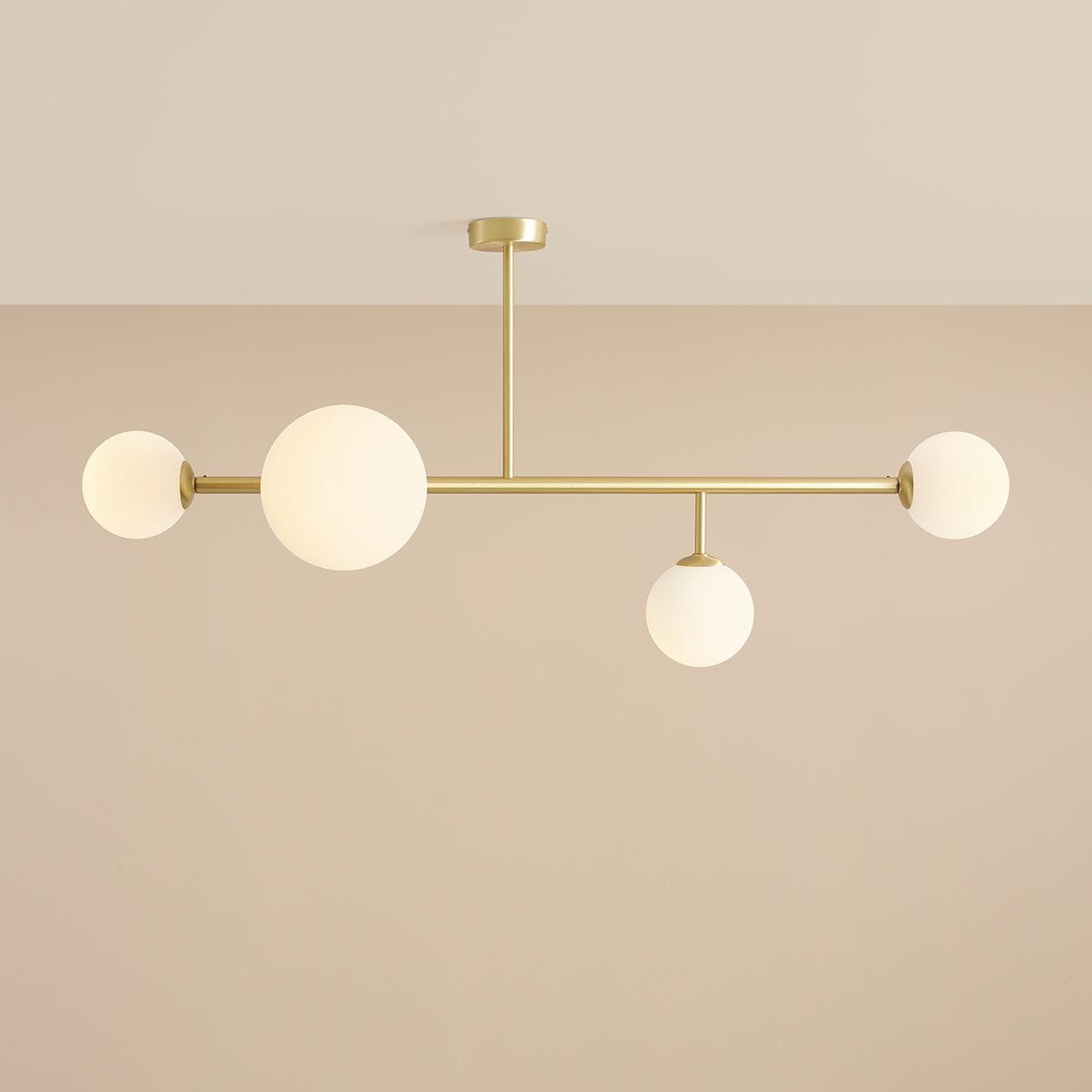 Lampa sufitowa Dione w kolorze mosiądzu, z czterema okrągłymi kloszami z białego szkła. Konstrukcja z metalowym stelażem, wisząca z sufitu, z równomiernie rozłożonymi źródłami światła. Idealna do nowoczesnych wnętrz.