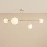Lampa sufitowa Dione w kolorze mosiądzu, z czterema okrągłymi kloszami z białego szkła. Konstrukcja z metalowym stelażem, wisząca z sufitu, z równomiernie rozłożonymi źródłami światła. Idealna do nowoczesnych wnętrz.