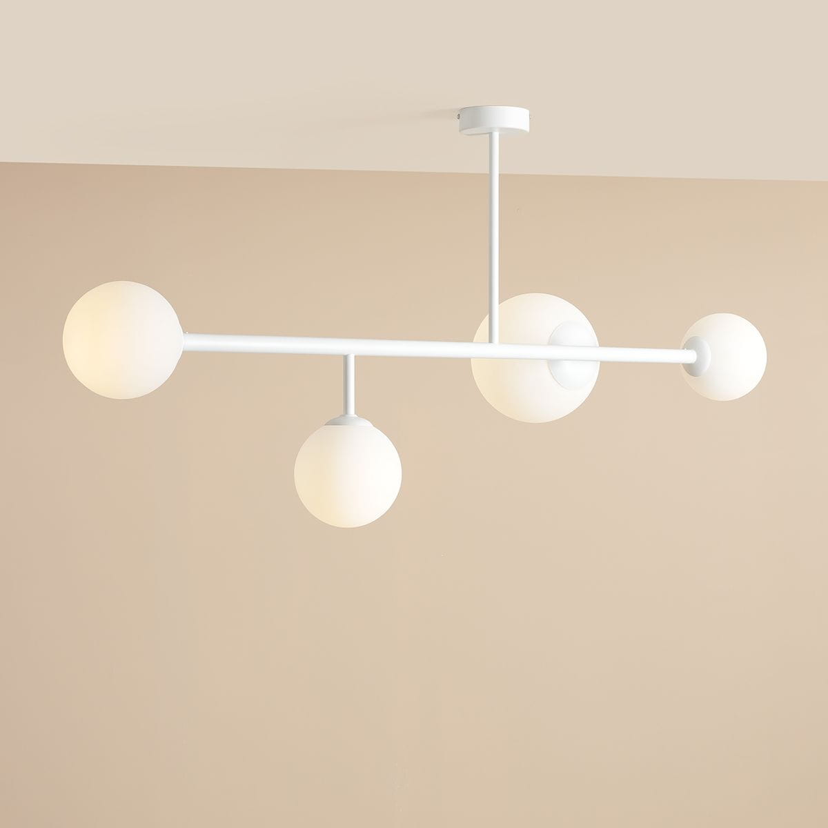 Lampa sufitowa Dione w kolorze białym, z czterema okrągłymi kloszami w matowym wykończeniu. Ułożona poziomo, z centralnym mocowaniem do sufitu. Klosze umieszczone na dwóch poziomach, co nadaje nowoczesny wygląd. Tło w neutralnym odcieniu.