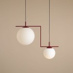 Lampa wisząca Zac II 2-punktowa w kolorze czerwonym z dwiema okrągłymi kloszami z matowego szkła. Ułożona w asymetryczny sposób, z większym kloszem zawieszonym wyżej i mniejszym niżej, na prostym, czerwonym stelażu. Tło w jasnym odcieniu beżu.