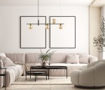 Lampa wisząca Bletter 4-punktowa w kolorze czarnym i bursztynowym, zawieszona w centralnej części pomieszczenia, z czterema okrągłymi kloszami. W tle widoczna jasna kanapa i minimalistyczne ramki na ścianie.