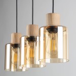 Lampa wisząca Orson 3-punktowa w kolorze czarnym i bursztynowym. Szklane klosze w odcieniu bursztynu z drewnianymi elementami, zawieszone na czarnych przewodach. Klosze mają cylindryczny kształt, eksponując żarówki. Tło jasne, minimalistyczne.