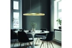Złota lampa wisząca Halo D120 LED z pilotem, o okrągłym kształcie, zawieszona nad okrągłym stołem. W tle ciemna ściana, okna z widokiem na zimowy krajobraz, czarne krzesła i stół z białym blatem.