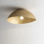 Lampa sufitowa Solaris S w kolorze złotym, 1-punktowa, z półkolistym kloszem o matowej powierzchni zewnętrznej i błyszczącym wnętrzem. Widoczna żarówka w centralnej części, montowana do sufitu. Tło jasne, minimalistyczne.
