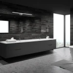 Kinkiet Shine LED IP44 w chromowanej obudowie, z jedną punktową lampą, umieszczony na ciemnym tle łazienki. Oświetlenie ma nowoczesny design, idealne do strefy umywalkowej. W tle widoczna elegancka umywalka z szafkami i dużym lustrem.