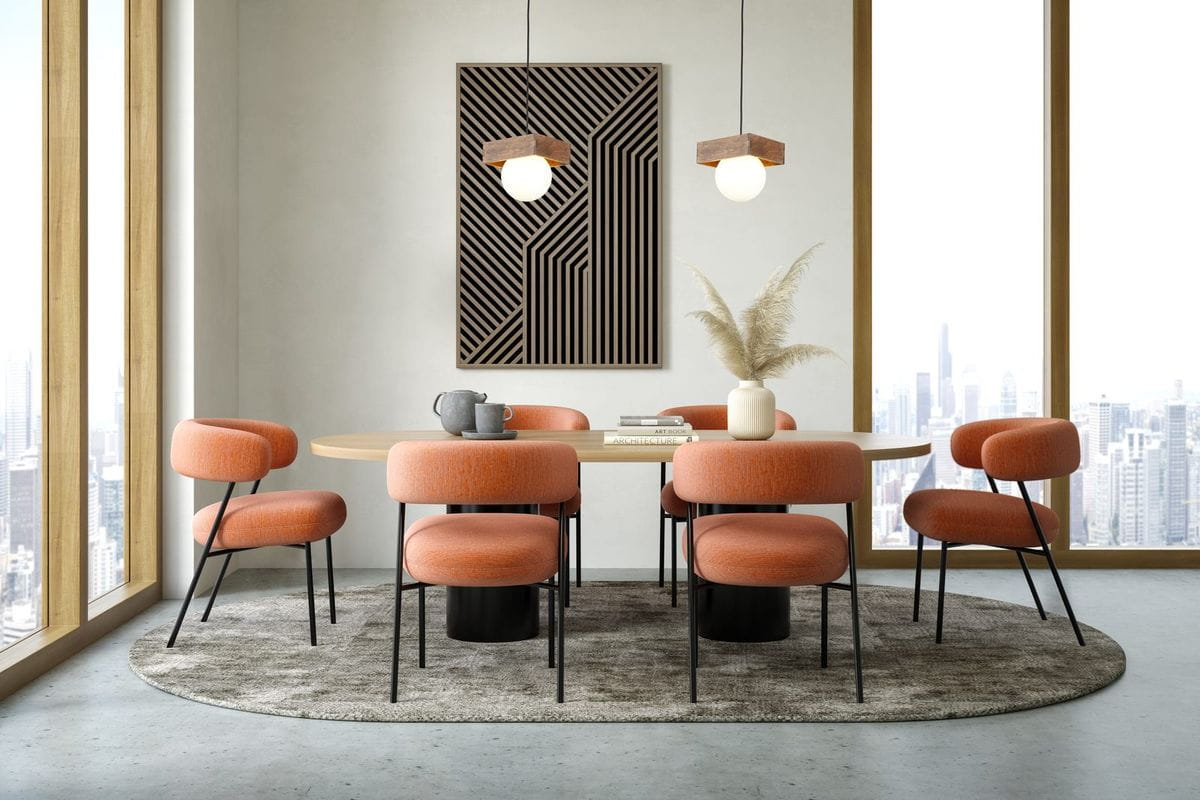 Lampa wisząca Bloom 1-punktowa w kolorze czarnym i brązowym, zawieszona nad okrągłym stołem w jadalni. W tle widoczna grafika oraz eleganckie, pomarańczowe krzesła na szarym dywanie. Jasne, nowoczesne wnętrze z dużymi oknami.
