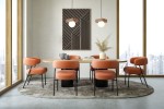 Lampa wisząca Bloom 1-punktowa w kolorze czarnym i brązowym, zawieszona nad okrągłym stołem w jadalni. W tle widoczna grafika oraz eleganckie, pomarańczowe krzesła na szarym dywanie. Jasne, nowoczesne wnętrze z dużymi oknami.