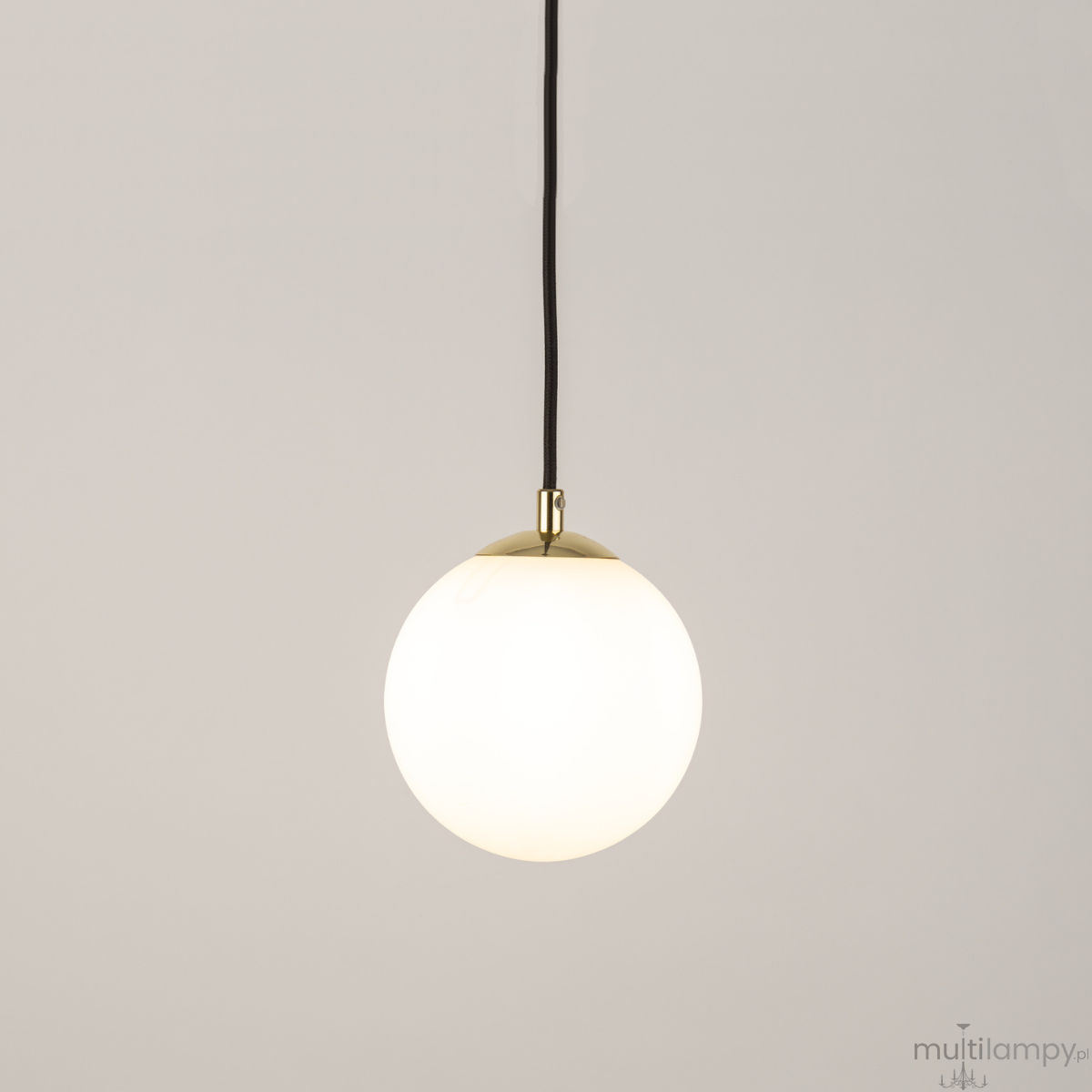 Lampa wisząca Piano w kolorze czarnym z okrągłym, białym kloszem. Zawieszona na czarnym przewodzie, z metalowym wykończeniem w kolorze złotym u góry. Prosty, minimalistyczny design, idealna do nowoczesnych wnętrz.