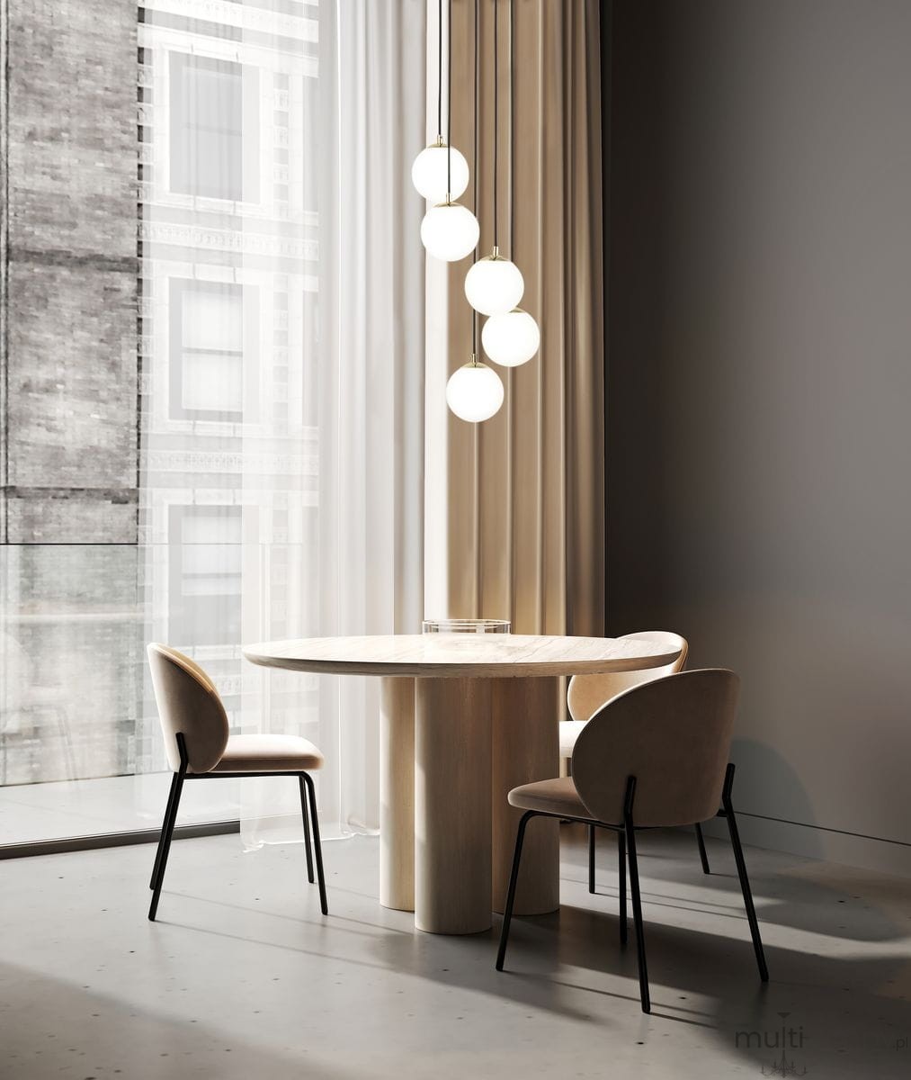 Lampa wisząca Piano 5-punktowa w kolorze czarnym z kulistymi kloszami w białym kolorze, zawieszona nad okrągłym stołem. Lampa składa się z pięciu źródeł światła, umieszczonych na różnych wysokościach, w nowoczesnym wnętrzu z jasnymi zasłonami.