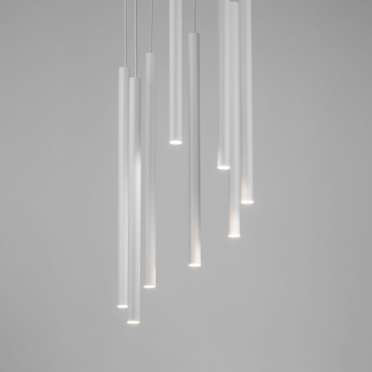Lampa wisząca Sopel Koło z 8 punktami świetlnymi, biała, składająca się z prostych, cylindrycznych elementów. Ujęcie z góry, w tle jasnoszare, podkreślające minimalistyczny design. Idealna do nowoczesnych wnętrz.