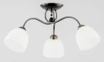 Lampa sufitowa Amarillo Grafit 3-punktowa z metalową, chromowaną podstawą i trzema białymi kloszami w kształcie dzwonu. Klosze są matowe, a lampa ma elegancką formę z delikatnymi zakrzywieniami. Zawieszona na suficie, w neutralnym otoczeniu.