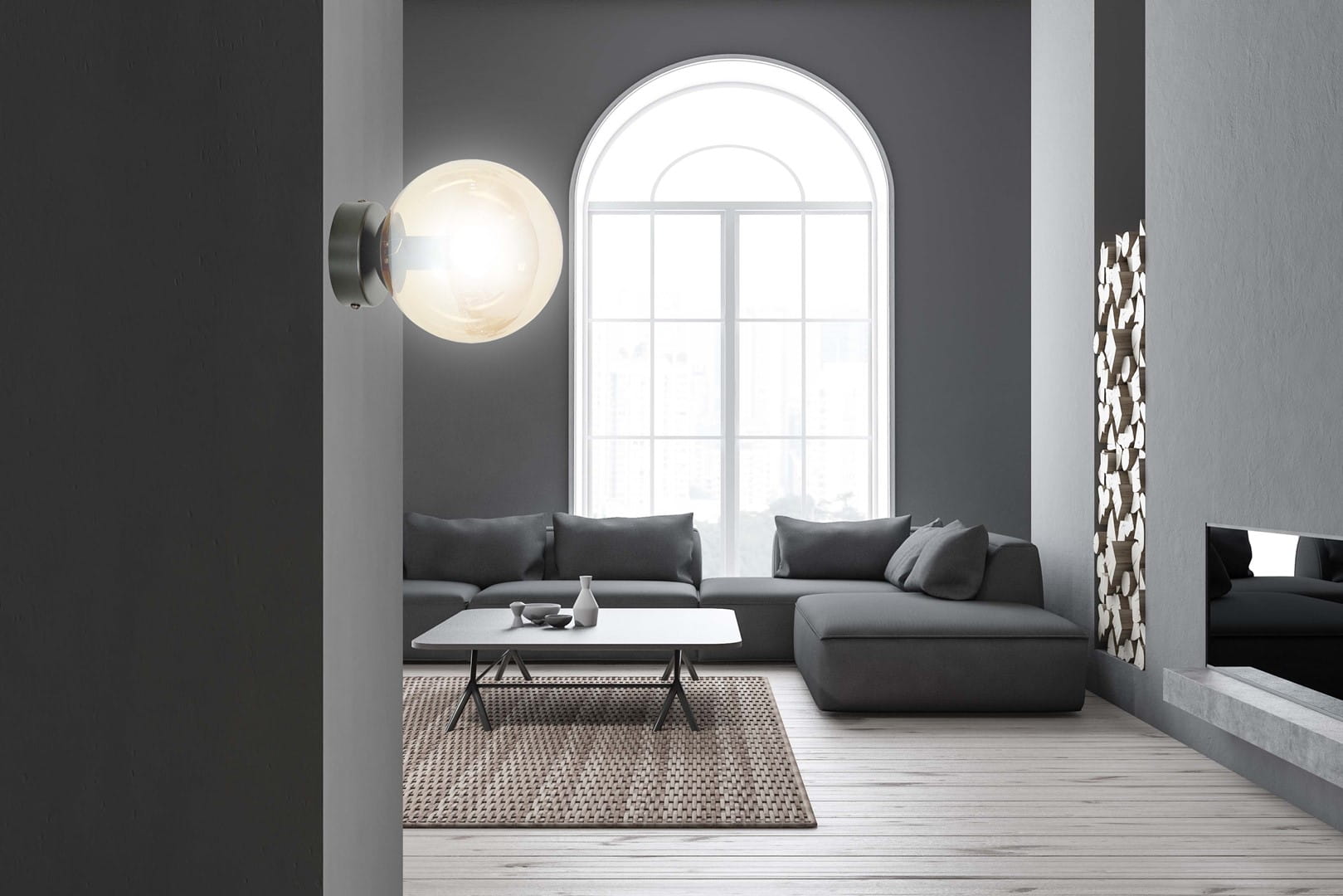 Kinkiet Rossi 1-punktowy w kolorze czarnym z bursztynowym kloszem, zamontowany na ścianie. Okrągły klosz emituje światło, a obok widoczna nowoczesna aranżacja wnętrza z szarym sofą i oknem w tle.