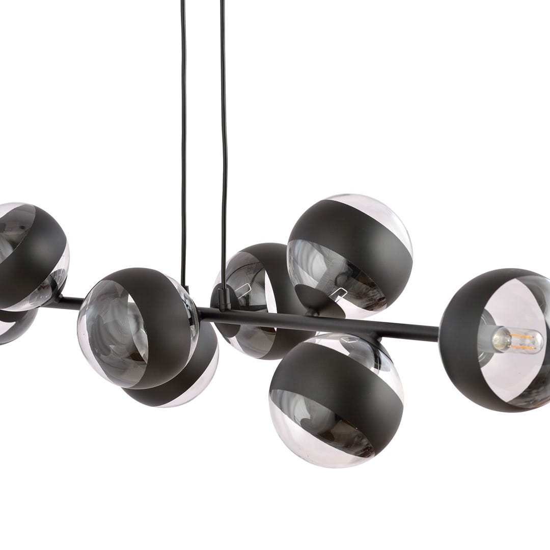 Lampa wisząca Rossi 8-punktowa w kolorze czarnym z przezroczystymi kulami. Osiem okrągłych kloszy o matowej strukturze, zawieszonych na cienkich linkach, w nowoczesnym designie. Kształt i położenie podkreślają elegancję i nowoczesność.
