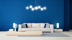 Lampa wisząca Rossi 8-punktowa w kolorze czarnym z mixem szklanych kloszy. Zawieszona na cienkich linkach, w nowoczesnym stylu, idealna do przestrzeni dziennej. Tło w intensywnym niebieskim kolorze, z jasnymi meblami i dekoracjami.