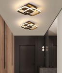 Czarna lampa sufitowa Duore z pilotem, z dwoma źródłami LED o mocy 68W. Kształt geometryczny z wykończeniem w kolorze złota, montowana na suficie. Widoczna w nowoczesnym wnętrzu z drewnianymi i ciemnymi akcentami.