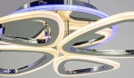 Lampa sufitowa Oslo z pilotem, z trzema źródłami LED (77W), w chromowanej obudowie. Na zdjęciu widoczne eleganckie, zakrzywione elementy w kolorze białym oraz niebieskie podświetlenie, zamontowane w konfiguracji wiszącej.
