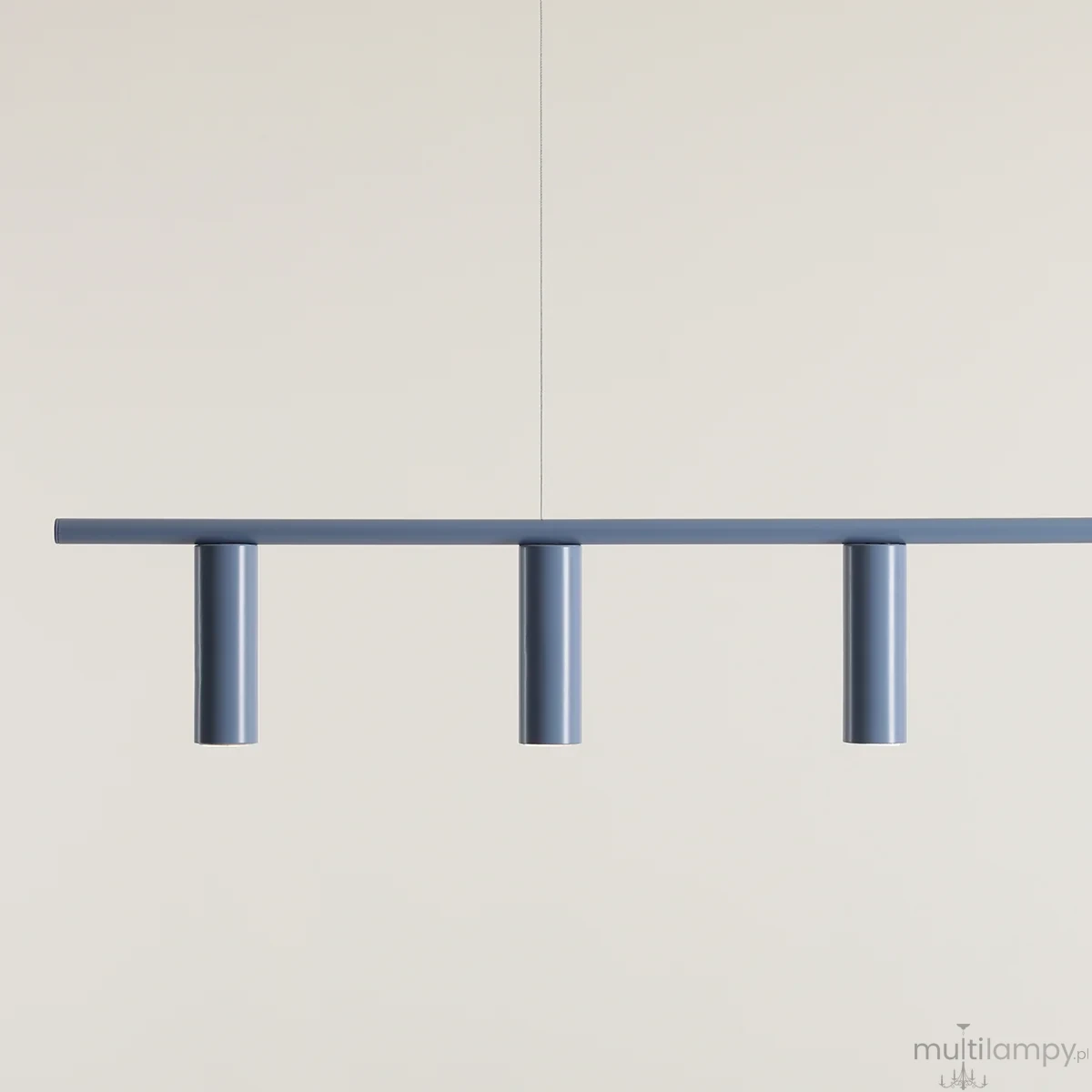 Lampa wisząca Trevo 6-punktowa w kolorze niebieskim, z prostokątnym stelażem i trzema cylindrycznymi punktami świetlnymi. Zawieszona na cienkich linkach, prezentuje minimalistyczny design na jasnym tle.