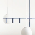 Lampa wisząca Trevo 6-punktowa w kolorze niebieskim. Składa się z prostokątnej belki z trzema cylindrycznymi punktami świetlnymi oraz dwiema okrągłymi, matowymi kloszami. Całość zawieszona na cienkich linkach, na jasnym tle.