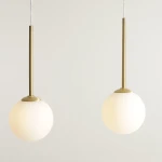 Lampa wisząca Bosso 3xE14 w kolorze mosiądzu. Posiada trzy okrągłe, matowe klosze na długich, smukłych zawieszeniach. Ujęcie frontalne, na jednolitym tle, ukazujące elegancki design i prostą formę.