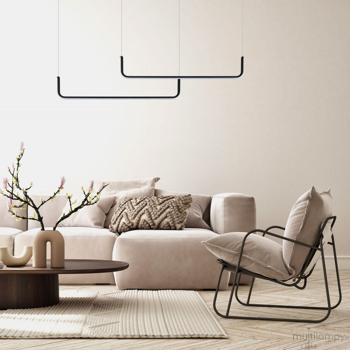 Czarna lampa wisząca Malawi LP-1015/2P z dwoma źródłami LED, umieszczona nad jasną sofą w nowoczesnym wnętrzu. Prosty, geometryczny kształt. W tle widoczna dekoracyjna gałązka z kwiatami i stół kawowy.