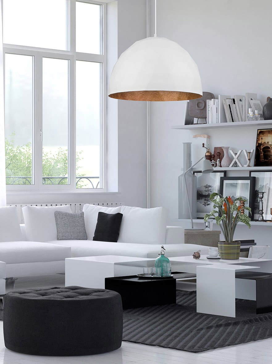 Lampa wisząca Diament D50 w kolorze białym z miedzianym wnętrzem, zawieszona w nowoczesnym wnętrzu. Kształt półkulisty, umieszczona nad białym stołem kawowym. W tle jasne ściany, okna i eleganckie meble.