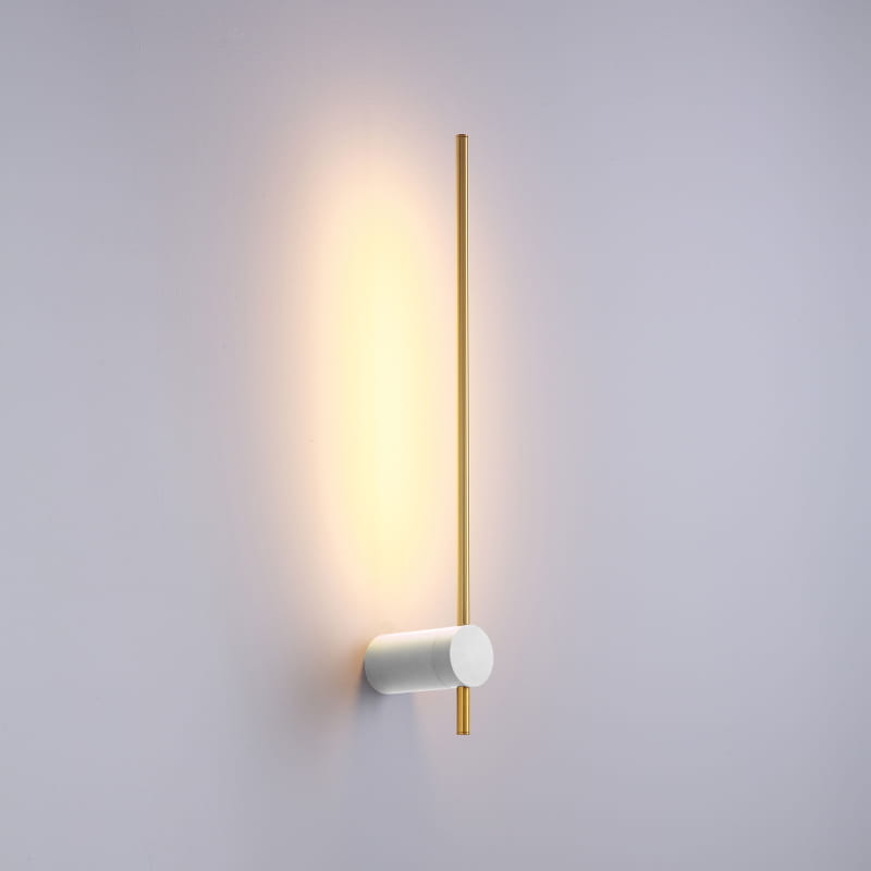 Kinkiet LED Wand 466 o mocy 6W, w kolorze białym i złotym. Posiada okrągłą podstawę i długi, prosty złoty klosz, emitujący ciepłe światło. Montowany na ścianie, w prostym, nowoczesnym stylu. Tło w jednolitym kolorze.