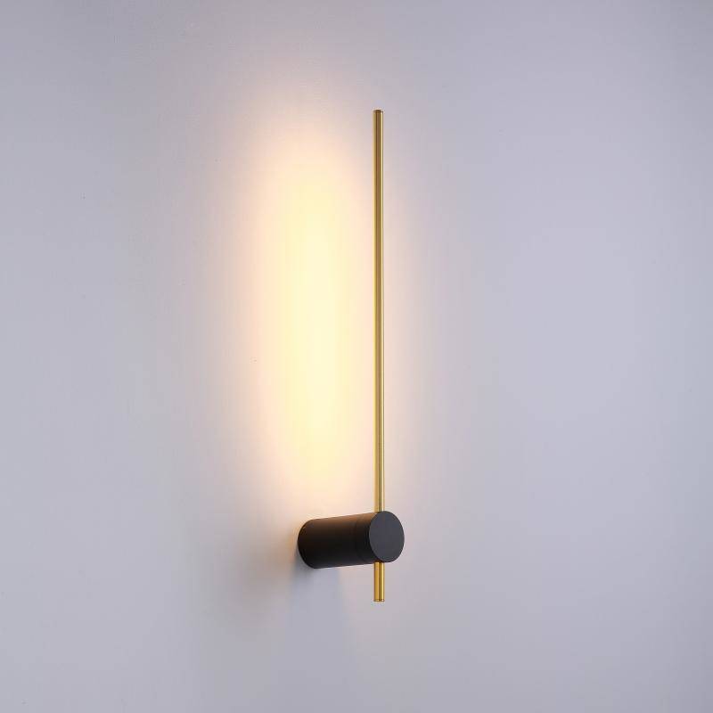 Kinkiet LED Wand 466, 6W, w kolorze czarnym i złotym. Ma prostą, pionową formę z czarnym okrągłym mocowaniem i złotą, smukłą rurką emitującą ciepłe światło. Zainstalowany na jasnej ścianie, podkreślający nowoczesny styl wnętrza.
