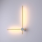 Kinkiet Wand 469 z dwoma źródłami LED 12W, w kolorze białym i złotym. Posiada minimalistyczny design z okrągłą podstawą i dwoma prostokątnymi ramionami, emitującymi ciepłe światło. Zamontowany na ścianie, w prostym otoczeniu.