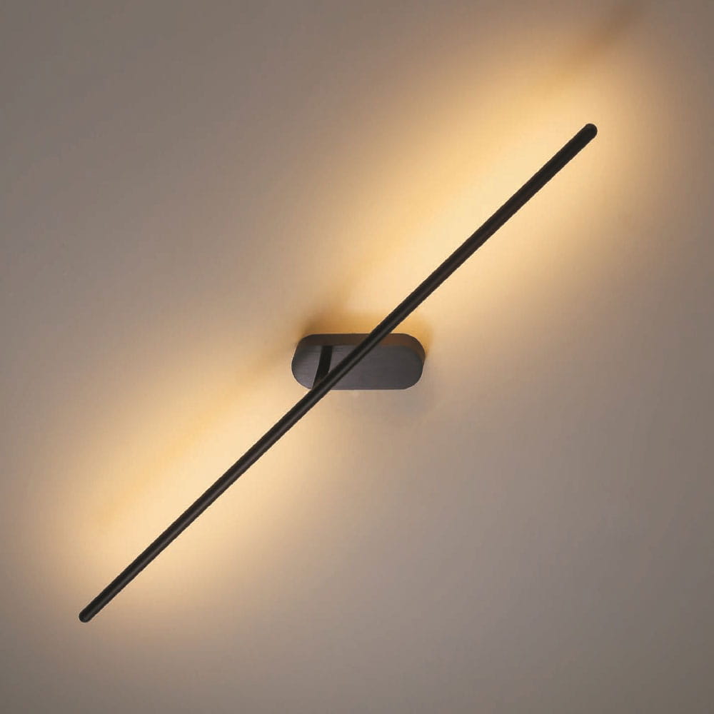 Kinkiet LED Line 243A o mocy 10W w kolorze czarnym, zamontowany na ścianie, z prostokątną podstawą i długim, cienkim ramieniem emitującym ciepłe światło. Kąt ujęcia pokazuje produkt w zbliżeniu, podkreślając minimalistyczny design.