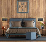 Kinkiet Hotels 417P w kolorze czarnym z dwoma diodami LED 7W, portem USB i ładowarką indukcyjną. Zainstalowany obok łóżka w aranżacji sypialni, z drewnianą ścianą w tle oraz dekoracyjnymi elementami jak zegar i kwiaty.