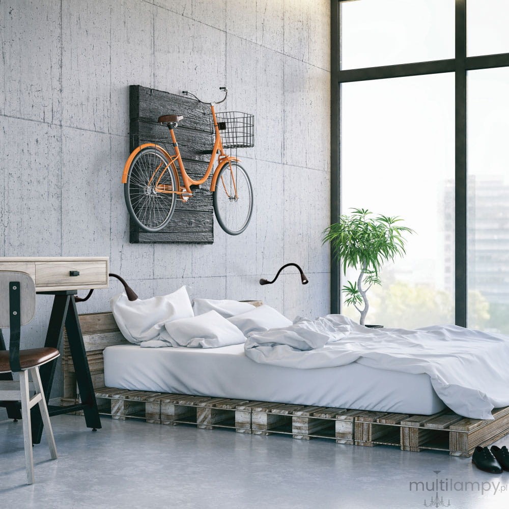 Kinkiet LED Sulta 220 o mocy 3W i barwie 3000K, w kolorze czarnym, zamontowany na ścianie obok łóżka w stylowym wnętrzu. Widoczny nowoczesny design oraz giętka konstrukcja umożliwiająca regulację kierunku światła.