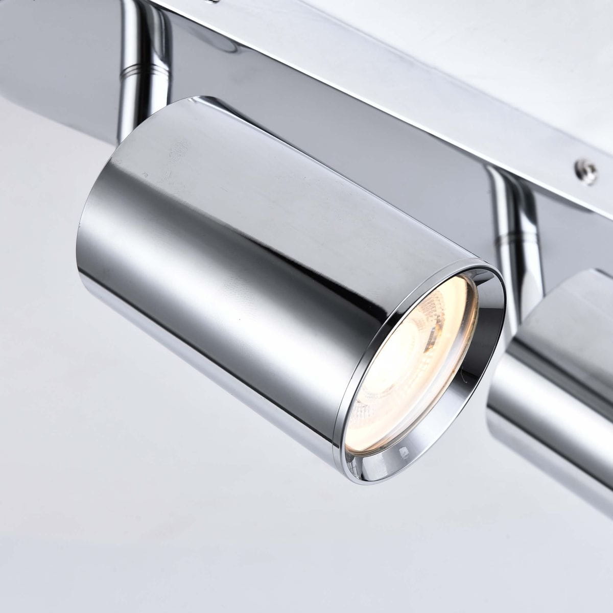 Lampa sufitowa Belize (spot) z trzema reflektorami GU10 w chromowanej obudowie. Ujęcie z boku, ukazujące błyszczący, cylindryczny kształt reflektora z widocznym źródłem światła. Tło neutralne, podkreślające nowoczesny design.