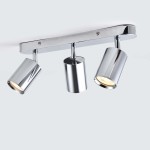 Lampa sufitowa Belize z trzema spotami, wykonana w chromie. Ujęcie z boku, pokazujące cylindryczne klosze skierowane w różne strony. Lampa montowana na prostokątnej podstawie, z widocznymi detalami mocowania.