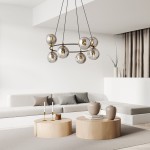 Lampa wisząca Azura z ośmioma kloszami E14 w czarnym i grafitowym kolorze, zawieszona nisko, we wnętrzu. Klosze mają przezroczyste, okrągłe formy, a podstawowe elementy są w kolorze złotym. Tło jasne, minimalistyczne z meblami w neutralnych barwach.