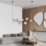 Lampa wisząca Ritz w kolorze czarnym i grafitowym, z siedmioma szklanymi kloszami na żarówki E14, zamontowana na eleganckim, zakrzywionym stelażu. Wisi nad nowoczesnym stołem kawowym w minimalistycznie urządzonym wnętrzu.