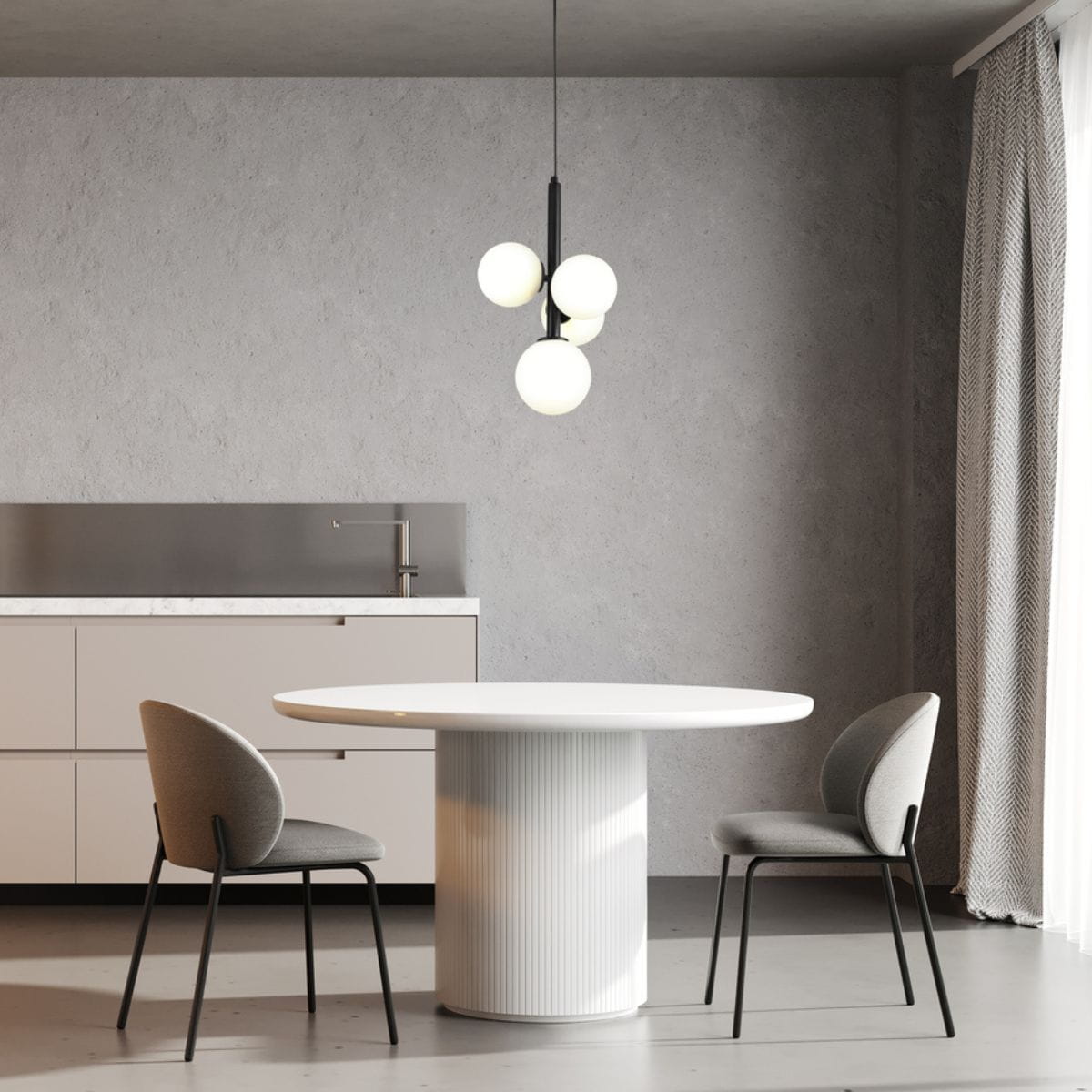 Lampa wisząca Perla z czterema białymi kulistymi kloszami na czarnym stelażu, zawieszona nad okrągłym białym stołem. W tle szare ściany i nowoczesne meble kuchenne, stylowe krzesła w odcieniu szarości.