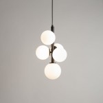 Lampa wisząca Perla z pięcioma kulkami G9, w kolorze czarno-białym. Kształt okrągłych, matowych kloszy na metalowej podstawie. Produkt zawieszony na czarnym przewodzie, prezentujący nowoczesny design. Tło jasne, jednolite.