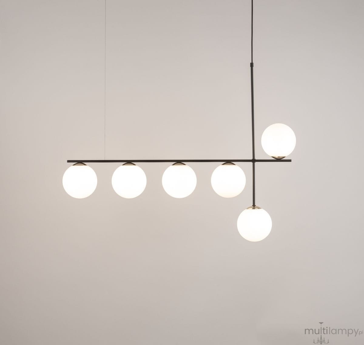 Lampa wisząca Silia z sześcioma okrągłymi kloszami w białym kolorze, umieszczona na czarnym, poziomym stelażu. Ujęcie frontalne, lampa zawieszona na cienkim przewodzie, z jedną kulą umiejscowioną wyżej. Tło jasne, jednolite.