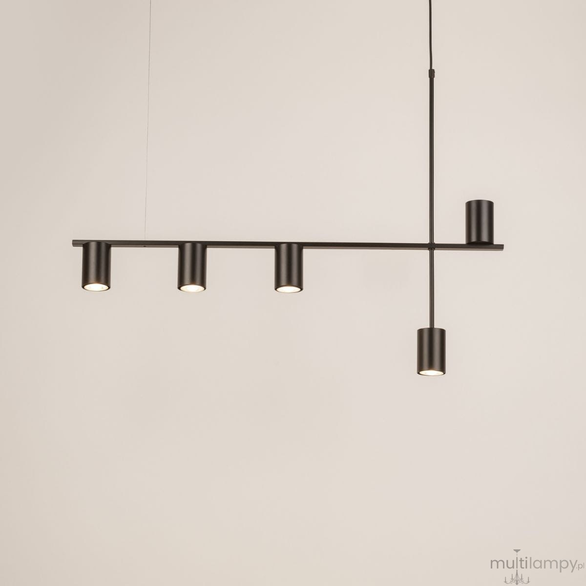 Lampa wisząca Vendo w kolorze czarnym z pięcioma oprawami na żarówki GU10. Posiada prostą, minimalistyczną konstrukcję z poziomą belką i pionowym mocowaniem, zawieszona na cienkim przewodzie. Tło jasne, co podkreśla elegancki design.
