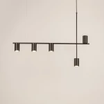 Lampa wisząca Vendo w kolorze czarnym z pięcioma oprawami na żarówki GU10. Posiada prostą, minimalistyczną konstrukcję z poziomą belką i pionowym mocowaniem, zawieszona na cienkim przewodzie. Tło jasne, co podkreśla elegancki design.